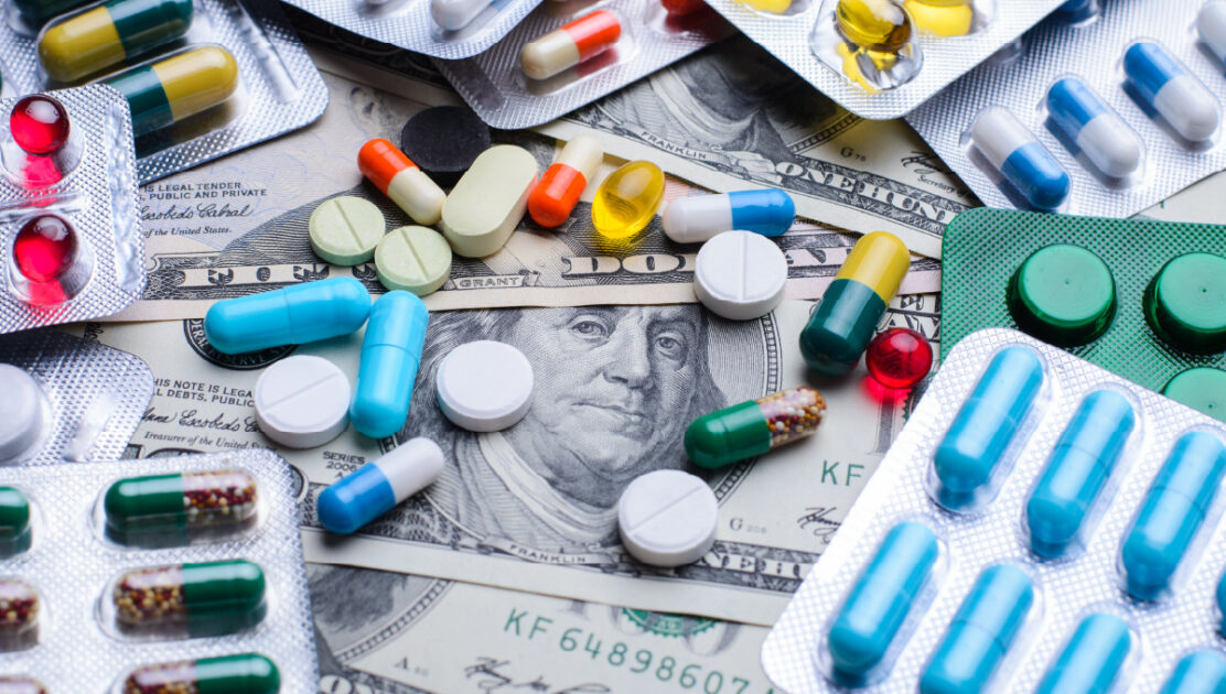 Medicare prescription drug prices represented by pills lying on top of paper currency.