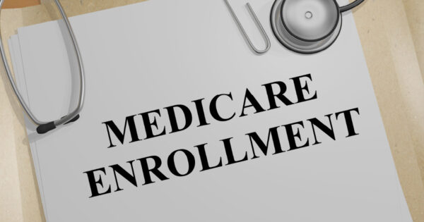 Medicare Enrollment typed on a page that is paper clipped to more pages.