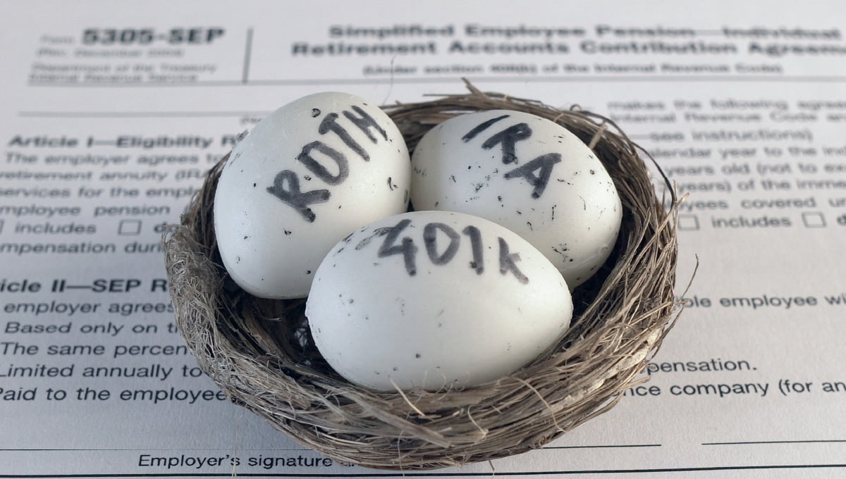 A nest with 3 eggs on top of a retirement tax form. Roth, IRA and 401k are written on the eggs.