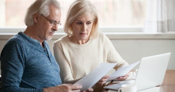 A retired couple reviewing premiums for a life insurance policy