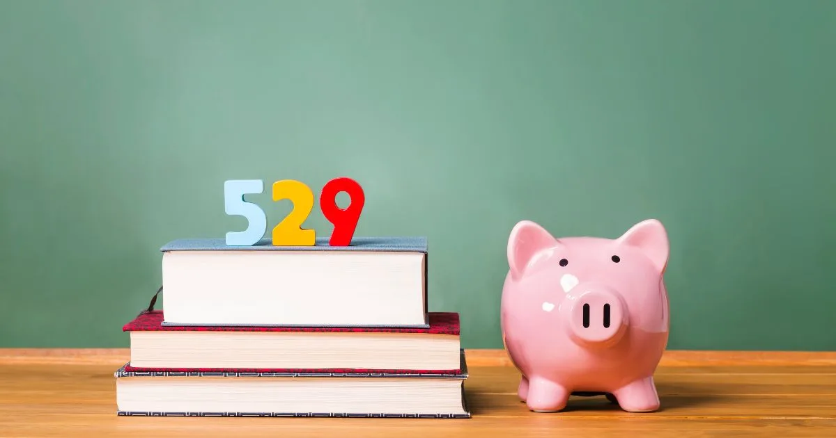 A piggy bank beside books with blocks in the shape of “529”