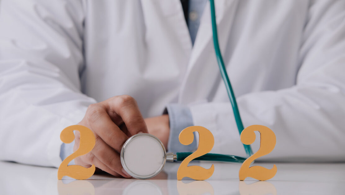 A medical professional holding a stethoscope. The circular end of the scope makes the 0 in the number 2022 meant to represent Medicare updates for 2022